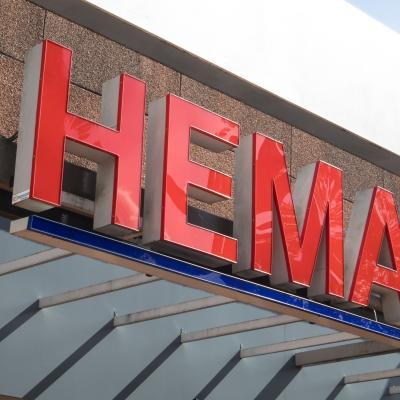 Voorgevel van een Hemavestiging ingezoomd op de rode Hema letters.