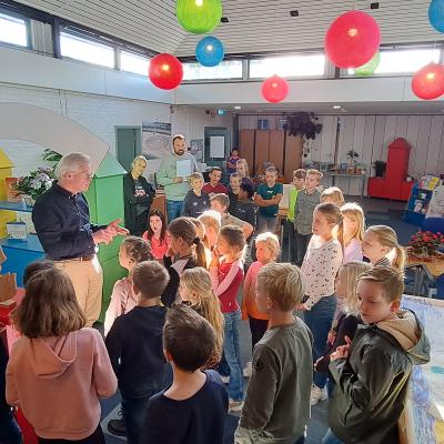 kinderen in staan in het klaslokaal en hoeren de uitslag van het geluksmoment