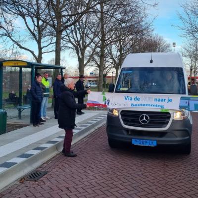 Haltetaxi staat achter spandoek wat wordt vastgehouden door 2 genodigden.
